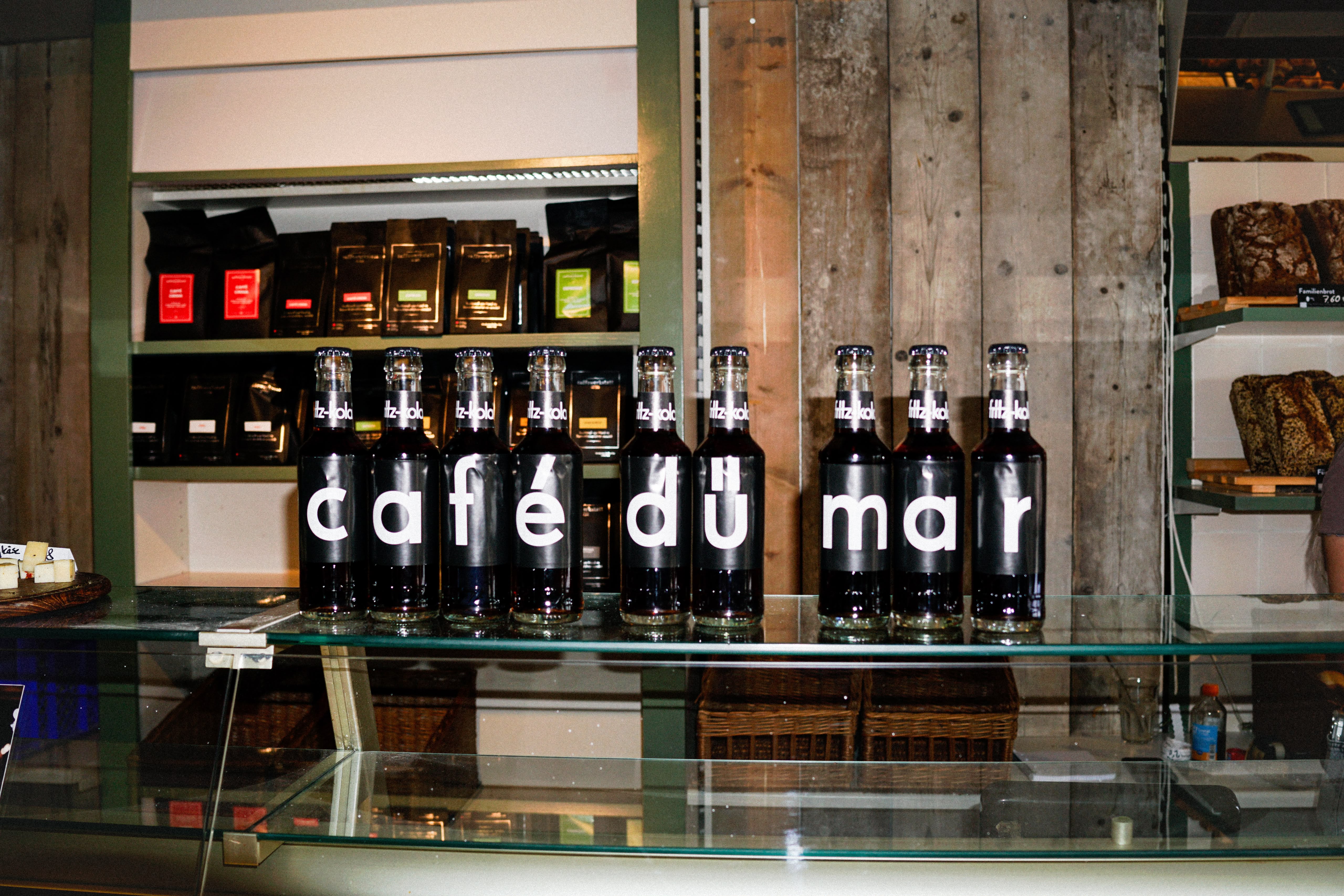Café Dü Mar Theke mit Getränken und Brotregal